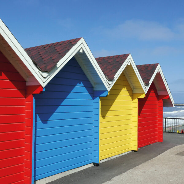 Row of colorful beach huts at Whitby, North Yorkshire, UK.