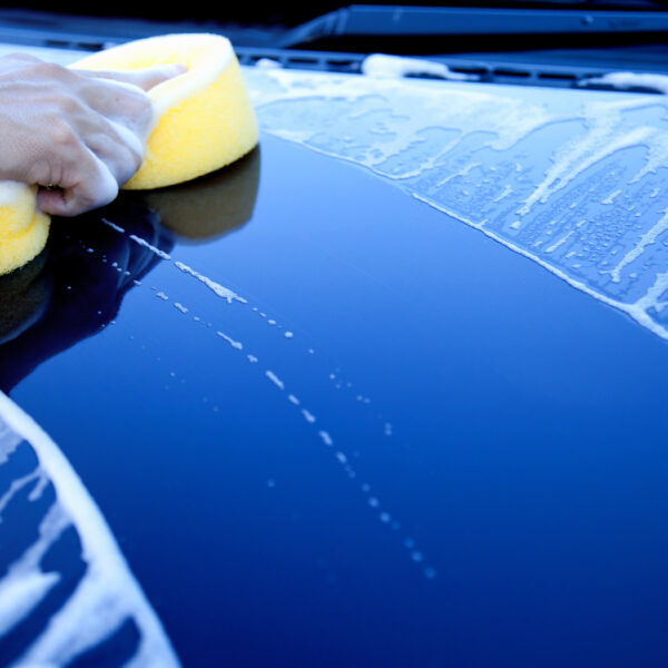 hand hold sponge over the car for washing